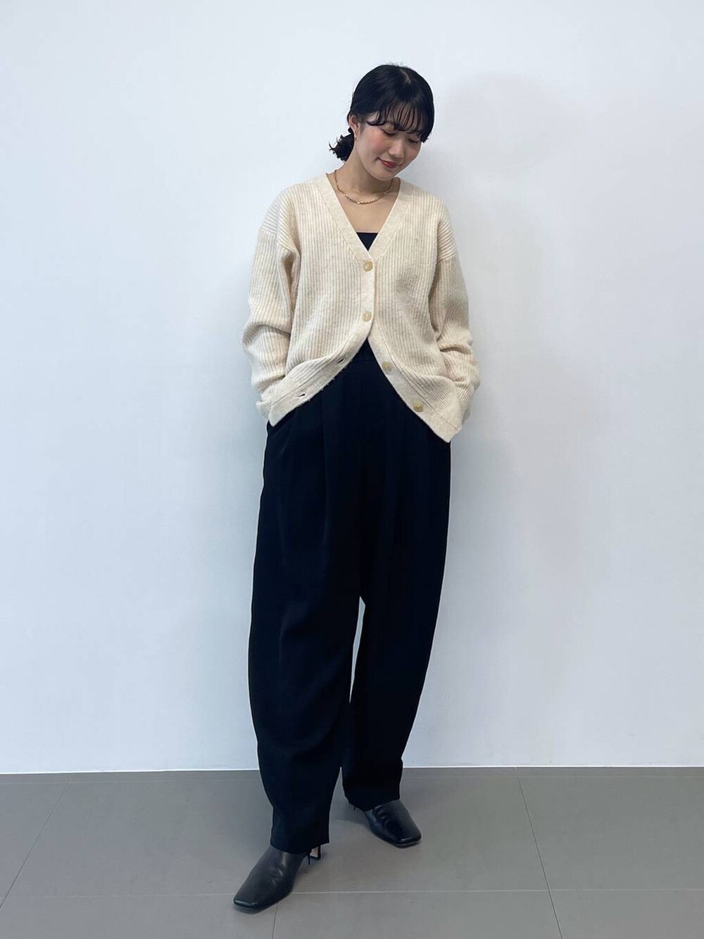 ブラック系のキャミソール、ブラック系のその他パンツ、ホワイト系のカーディガン/ボレロを着用したレディースの冬コーディネートの2枚目の写真