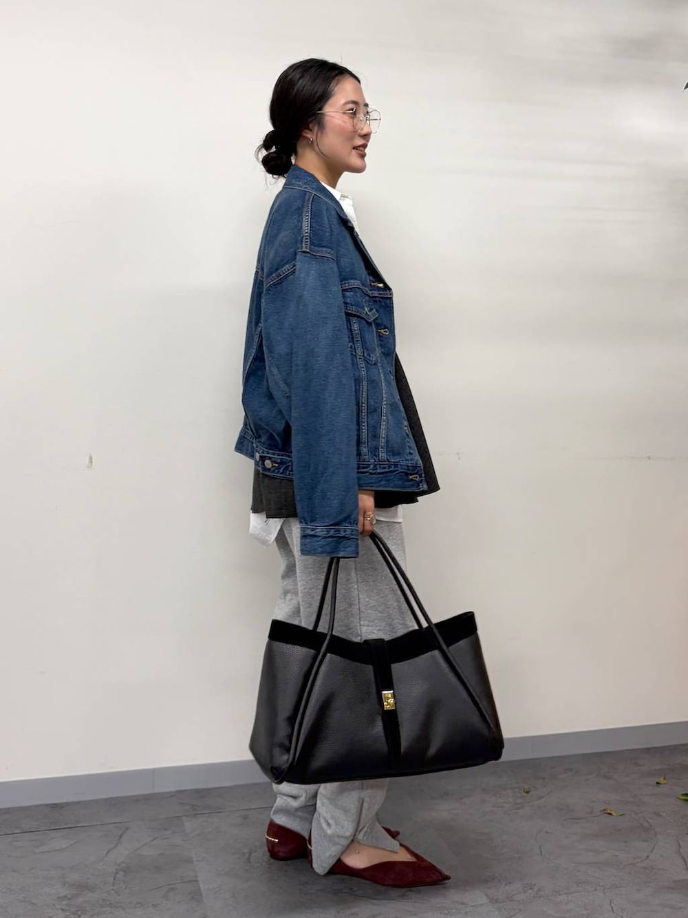 レッド系のパンプス、グレー系のスウェットパンツ、ブラック系のボストンバッグを着用したレディースの秋コーディネートの2枚目の写真