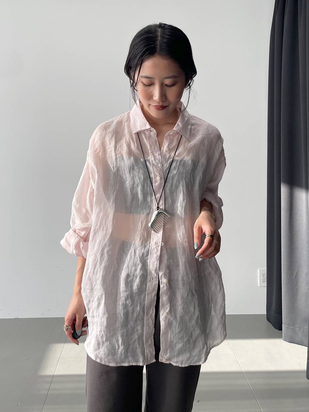 ピンク系のシャツ/ブラウス、グレー系のスウェットパンツを着用したレディースの春コーディネートの5枚目の写真