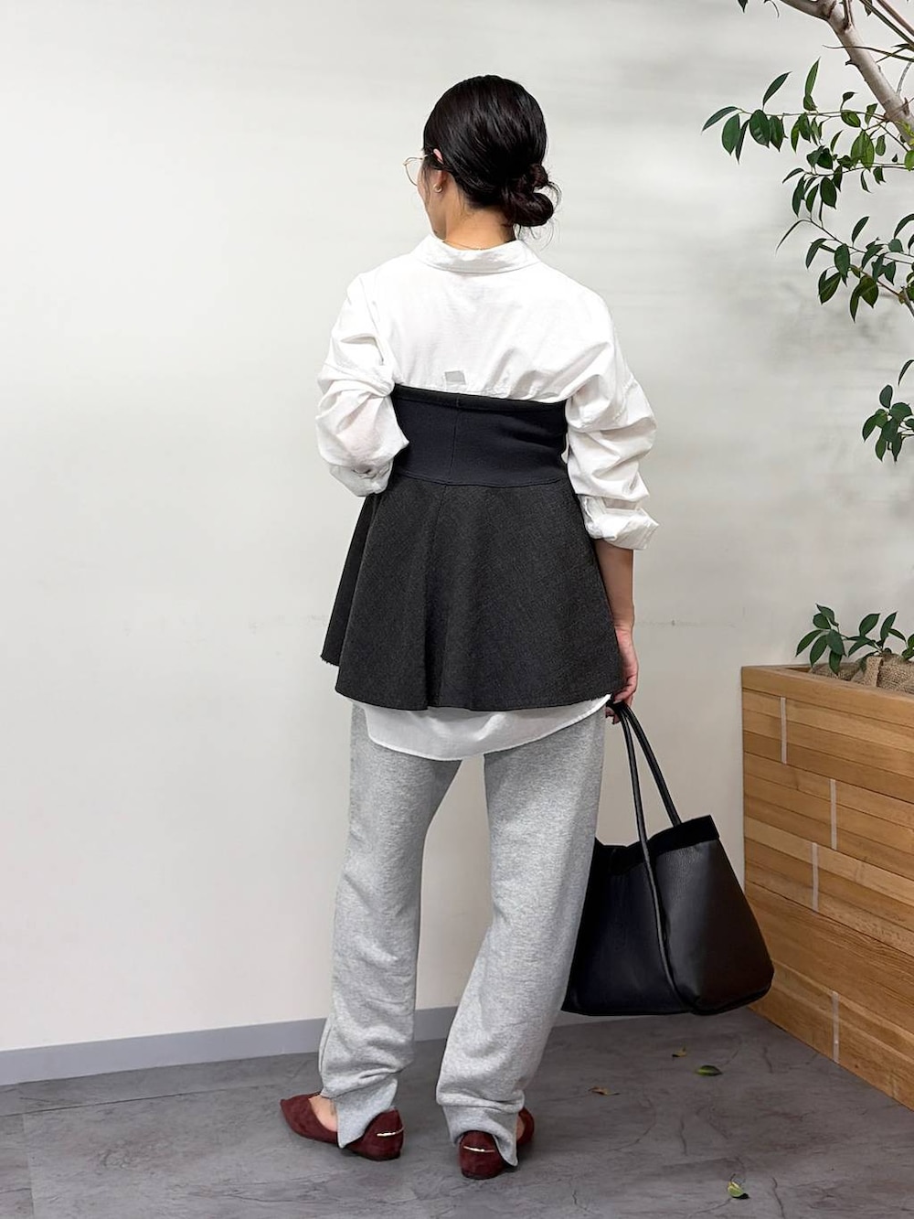 レッド系のパンプス、グレー系のスウェットパンツ、ブラック系のボストンバッグを着用したレディースの秋コーディネートの4枚目の写真