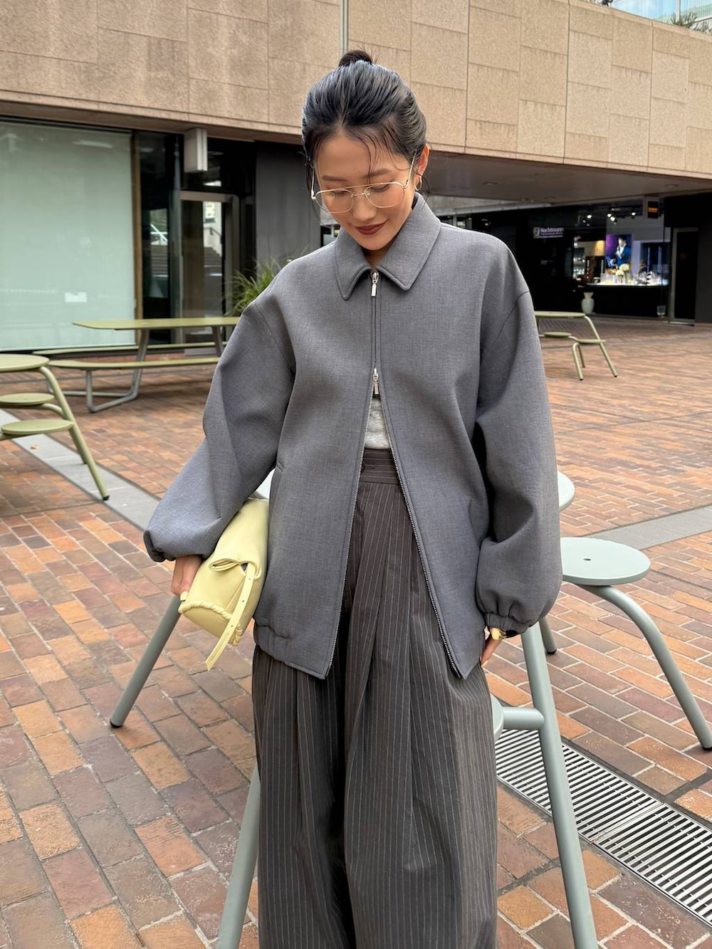 ベージュ系のパンプス、イエロー系のハンドバッグ、グレー系のTシャツ/カットソーを着用したレディースの春コーディネートの4枚目の写真