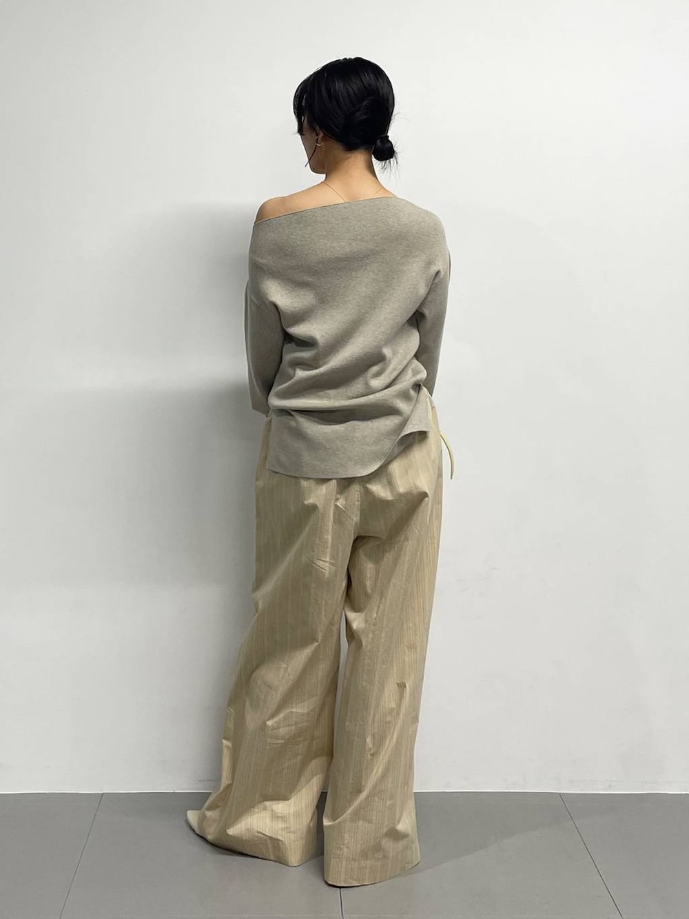 ベージュ系のパンプス、イエロー系のハンドバッグ、ベージュ系のその他パンツを着用したレディースの冬コーディネートの5枚目の写真