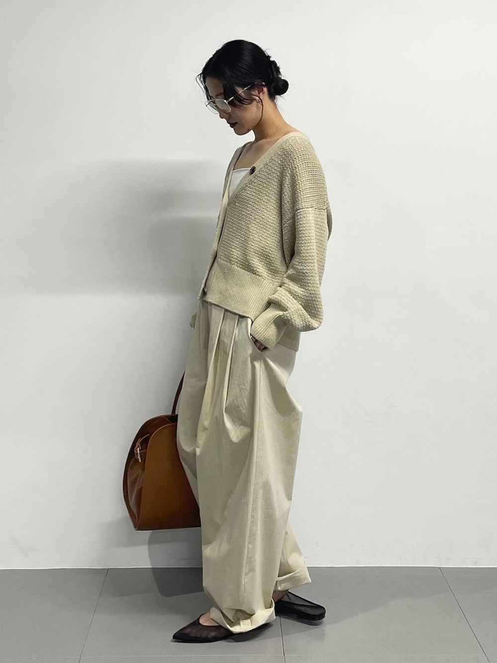 ブラック系のパンプス、ベージュ系のカーディガン/ボレロ、ブラウン系のボストンバッグを着用したレディースの春コーディネートの4枚目の写真