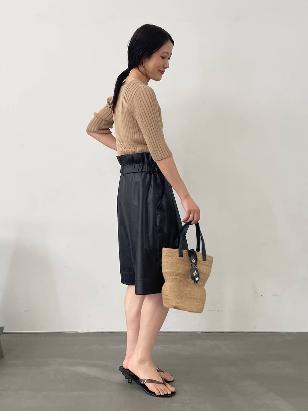 ブラック系のその他パンツ、ベージュ系のカーディガン/ボレロ、ベージュ系のかごバッグを着用したレディースの夏コーディネートの2枚目の写真