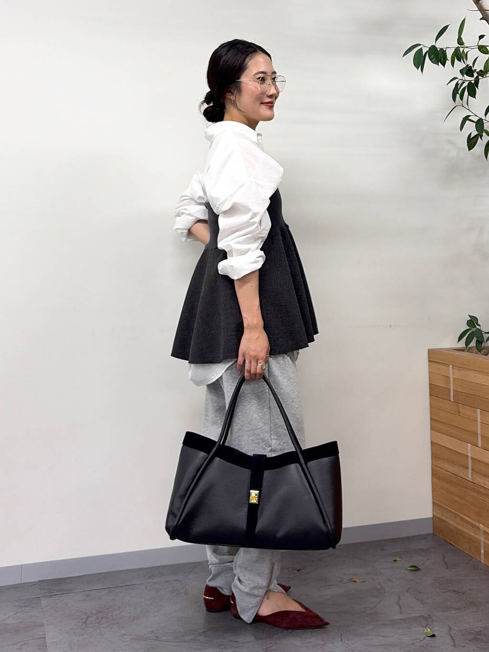 レッド系のパンプス、グレー系のスウェットパンツ、ブラック系のボストンバッグを着用したレディースの秋コーディネートの2枚目の写真