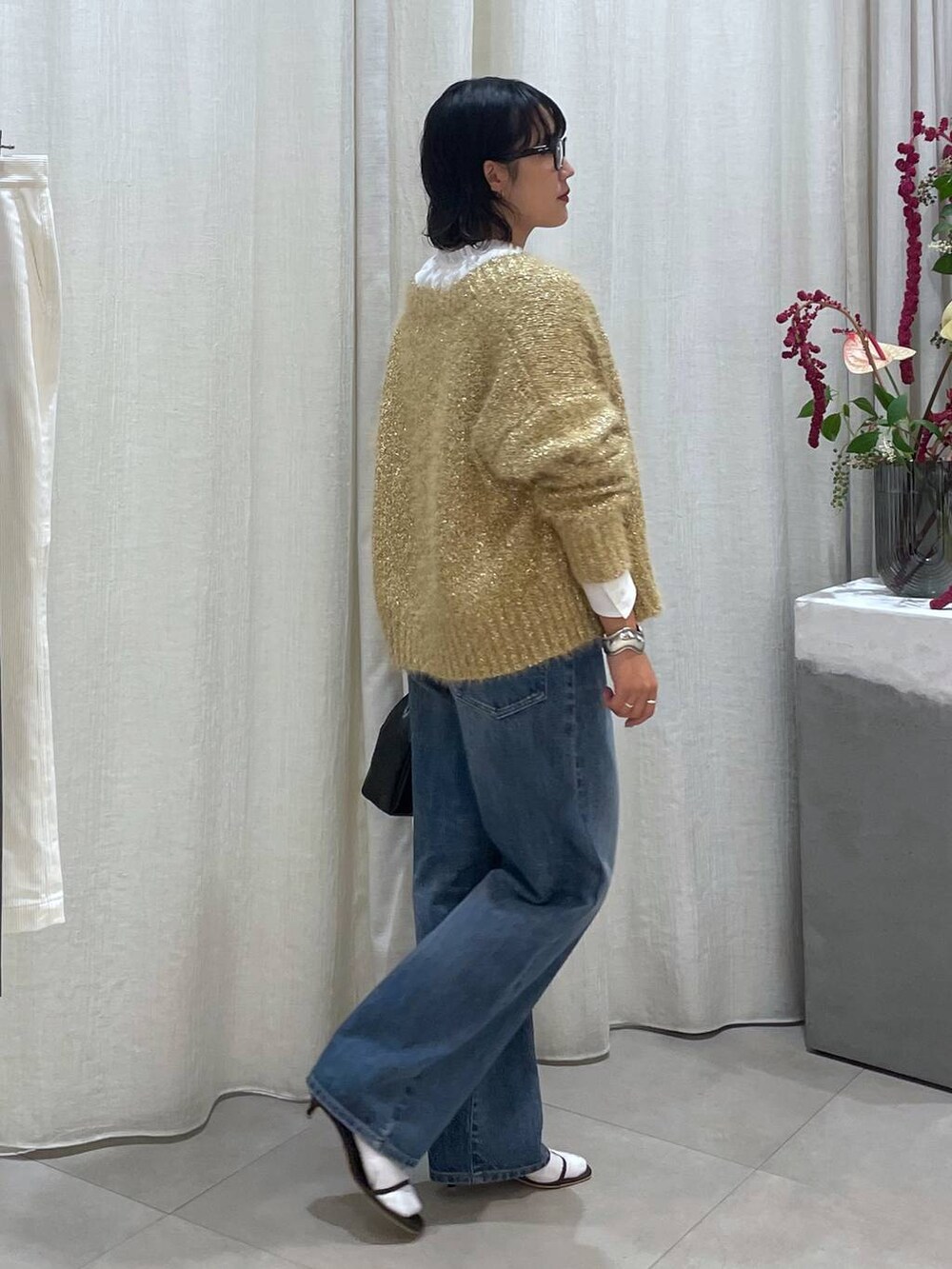 ブルー系のデニムパンツ、ブラウン系のサンダル、ホワイト系のシャツ/ブラウスを着用したレディースの秋コーディネートの5枚目の写真