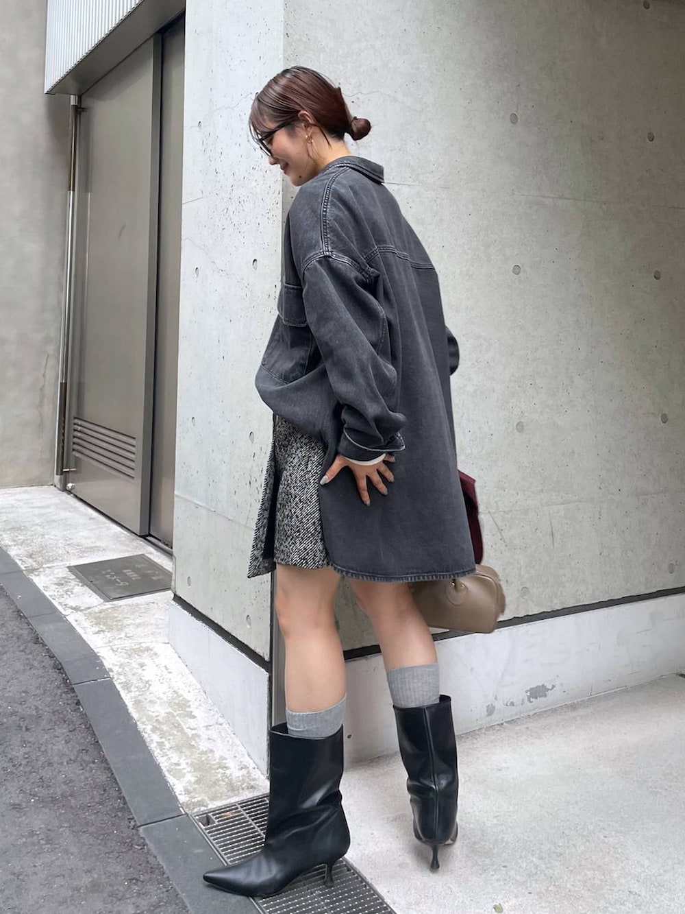 ホワイト系のカーディガン/ボレロ、ベージュ系のハンドバッグ、ブラック系のブーツを着用したレディースの秋コーディネートの3枚目の写真