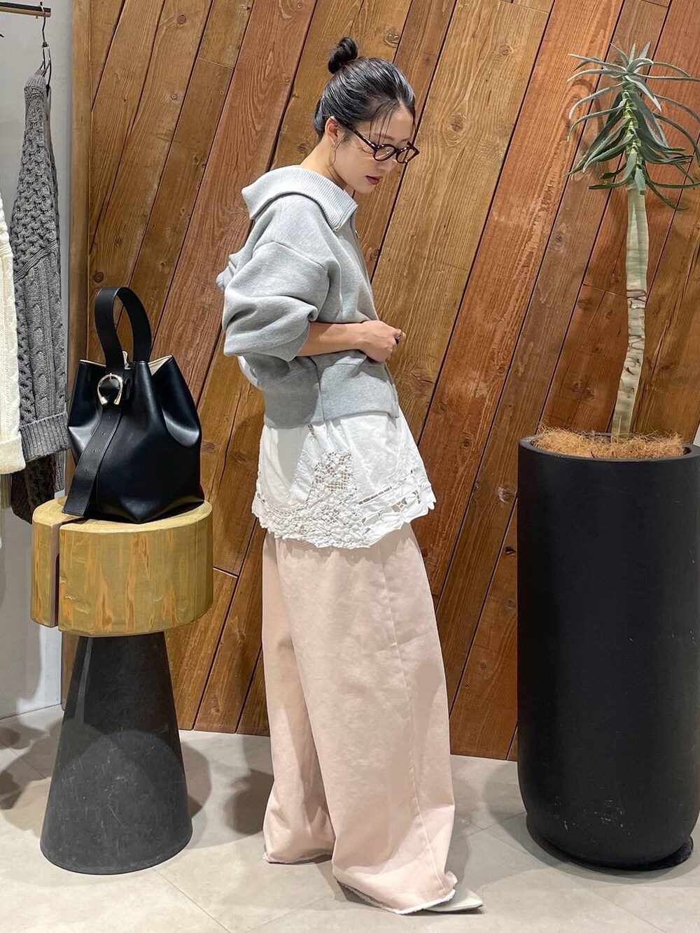 ピンク系のデニムパンツ、ベージュ系のパンプス、グレー系のスウェットを着用したレディースの冬コーディネートの4枚目の写真