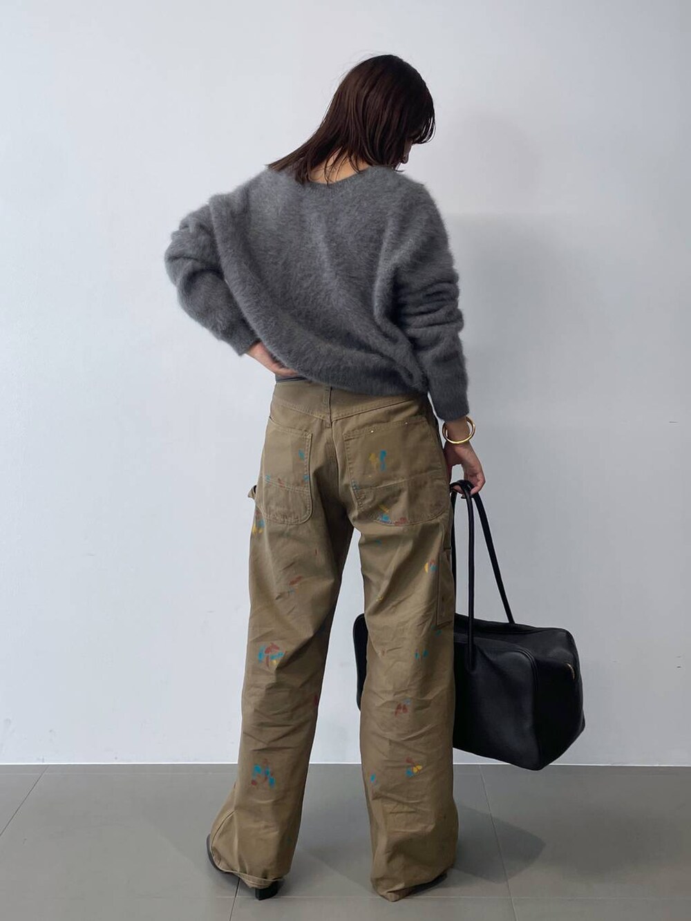 グレー系のニット/セーター、ブラック系のボストンバッグ、ブラック系のブーツを着用したレディースの秋コーディネートの4枚目の写真