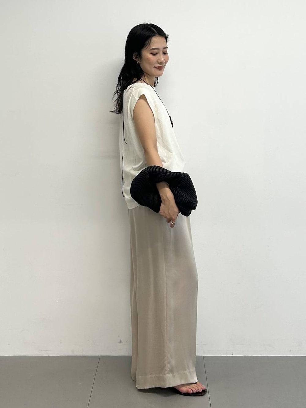 ベージュ系のその他パンツ、ホワイト系のTシャツ/カットソー、ブラック系のサンダルを着用したレディースの夏コーディネートの4枚目の写真