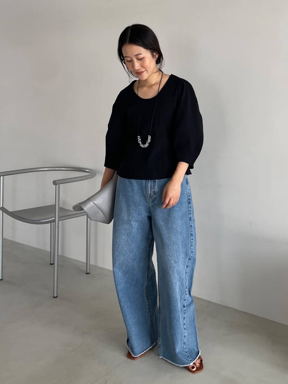 ブルー系のデニムパンツ、ブラック系のTシャツ/カットソー、グレー系のショルダーバッグを着用したレディースの春コーディネートの2枚目の写真