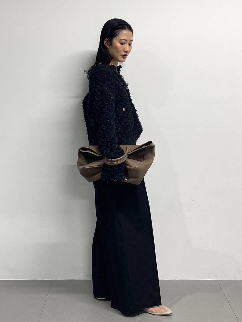 ベージュ系のパンプス、ブラック系のノーカラージャケット、ブラック系のチノパンツを着用したレディースの冬コーディネートの3枚目の写真