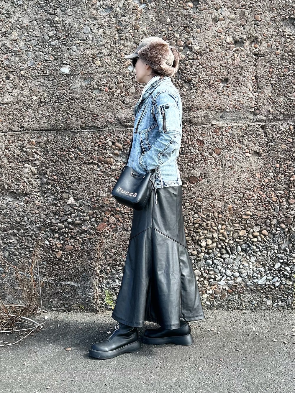 ブルー系のデニムジャケット、ブラック系のスカート、ブラック系のブーツを着用したレディースの秋コーディネートの3枚目の写真