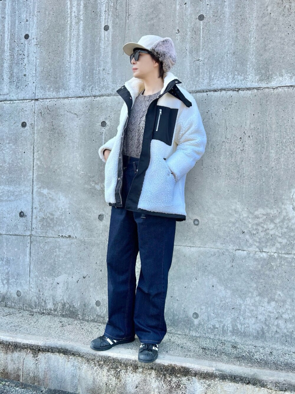 ホワイト系のブルゾン、ブラウン系のニット/セーター、ブルー系のその他パンツを着用したレディースの冬コーディネートの4枚目の写真