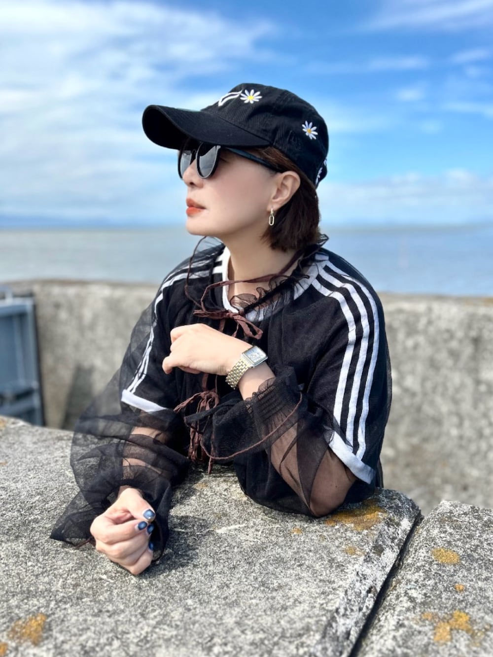 ブラック系のTシャツ/カットソー、ブラック系のワンピース、ブルー系のデニムパンツを着用したレディースの秋コーディネートの5枚目の写真