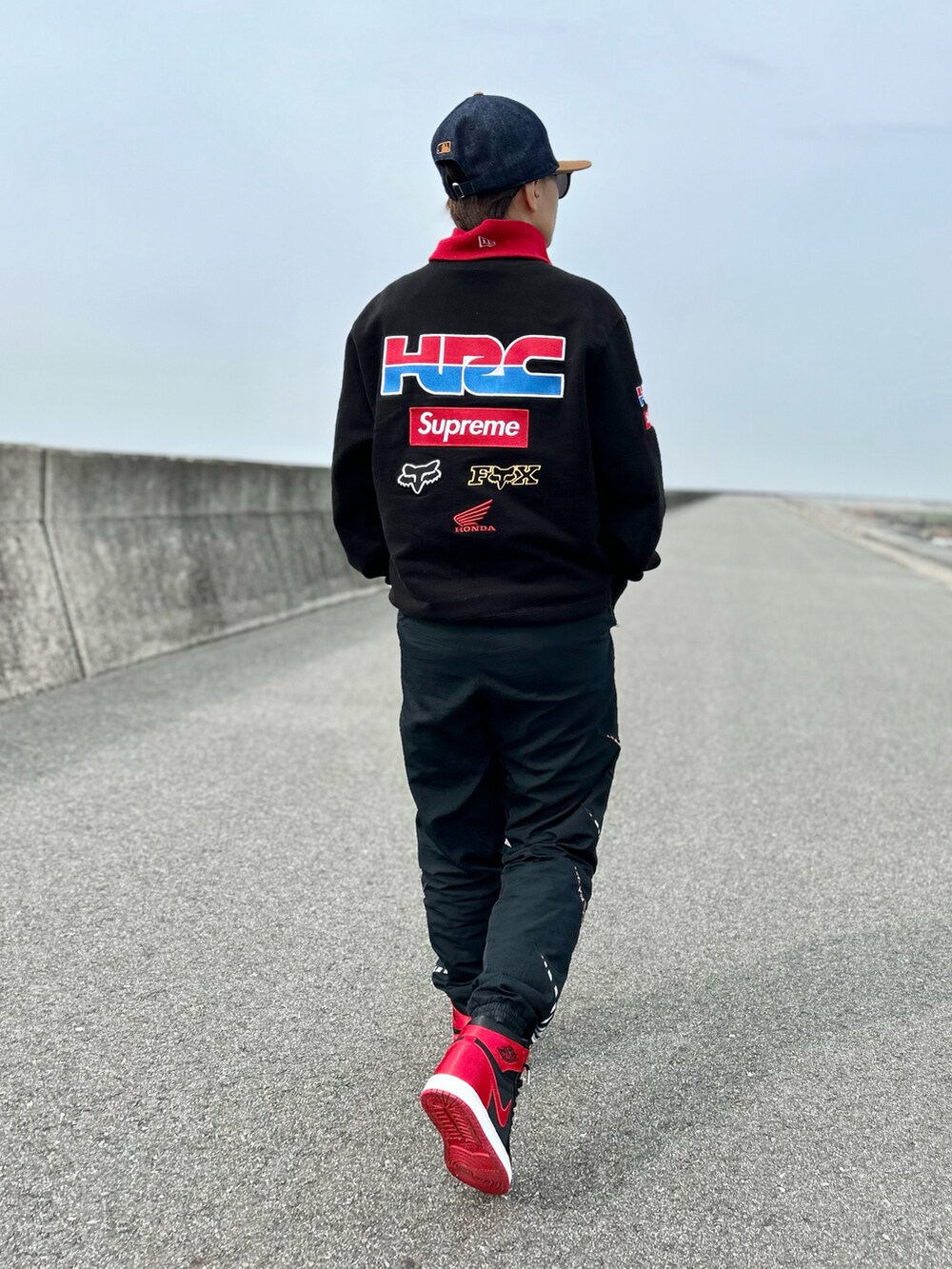 ブラック系のスウェット、ブラック系のパンツ、レッド系のスニーカーを着用したレディースの冬コーディネートの4枚目の写真