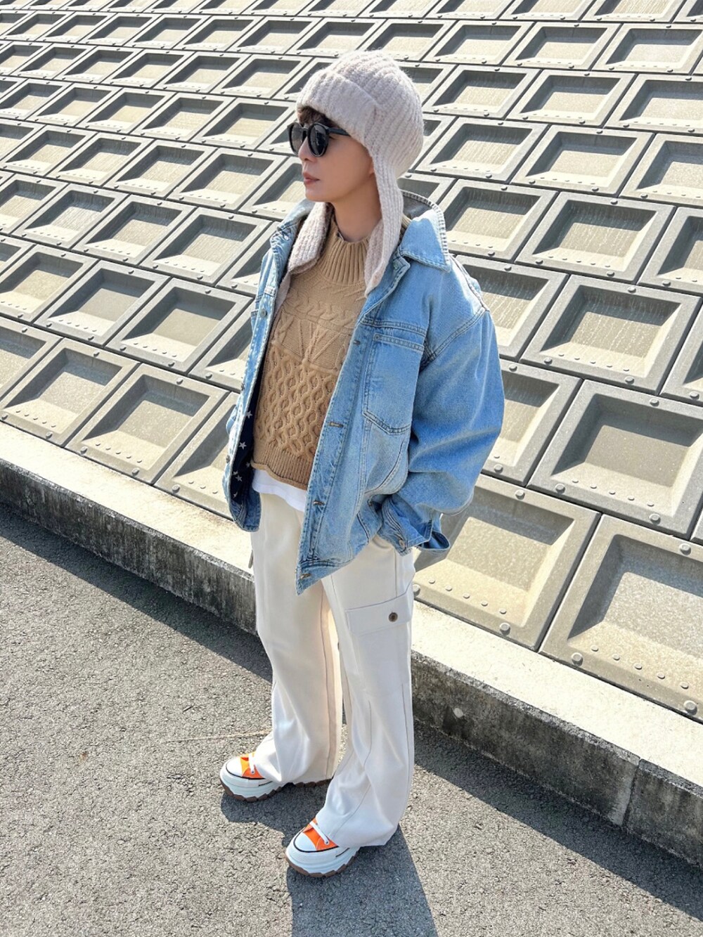 ホワイト系のパンツ、ブルー系のデニムジャケット、オレンジ系のスニーカーを着用したレディースの秋コーディネートの2枚目の写真