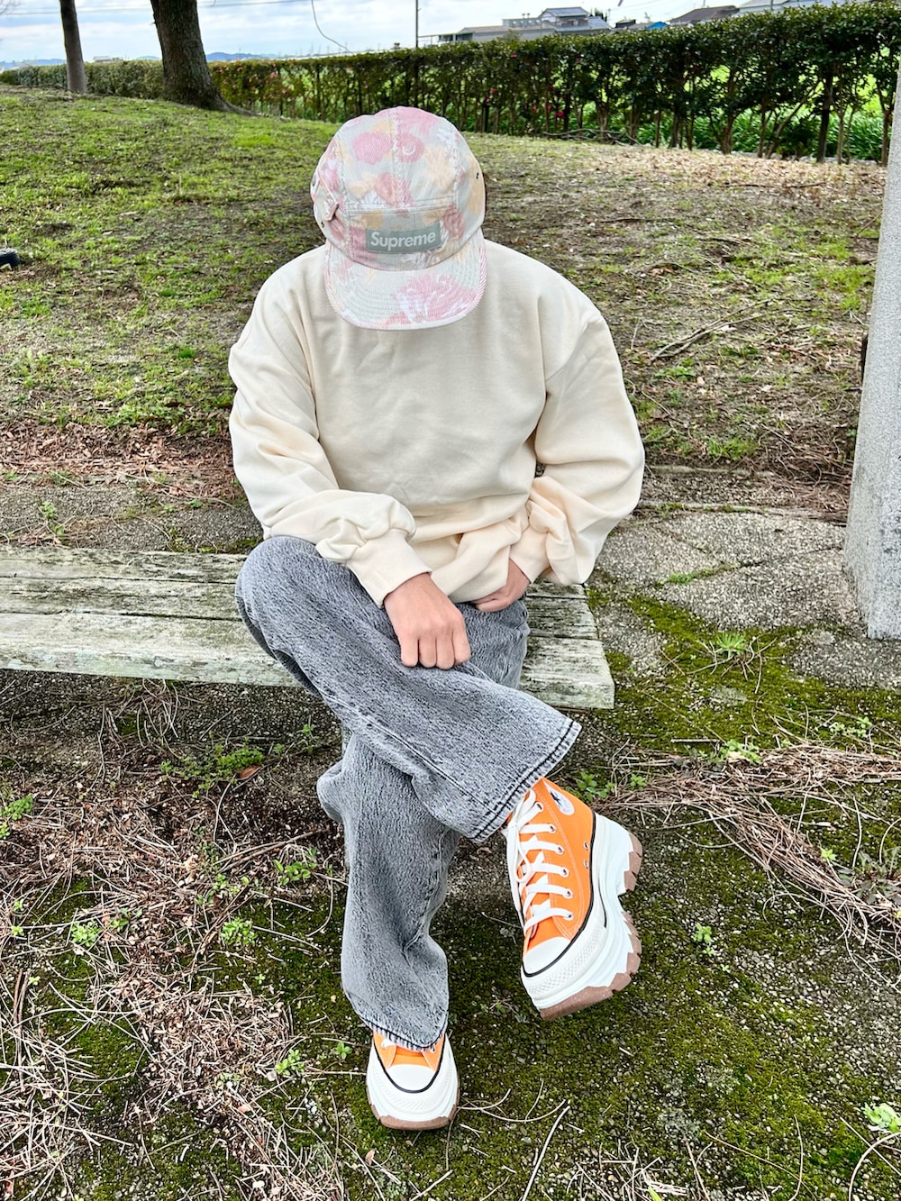 ブラック系のデニムパンツ、ホワイト系のスウェット、オレンジ系のスニーカーを着用したレディースの春コーディネートの3枚目の写真