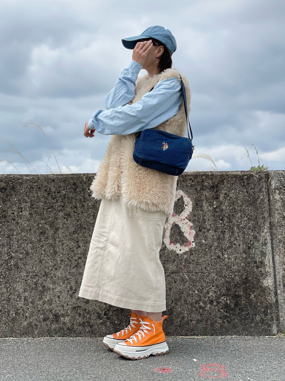 ブルー系のショルダーバッグ、ホワイト系のワンピース、ブルー系のTシャツ/カットソーを着用したレディースの春コーディネートの5枚目の写真