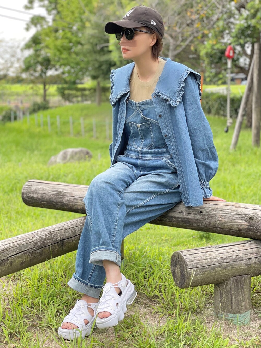 ブルー系のシャツ/ブラウス、ブルー系のサロペット/オーバーオール、ホワイト系のサンダルを着用したレディースの夏コーディネートの2枚目の写真