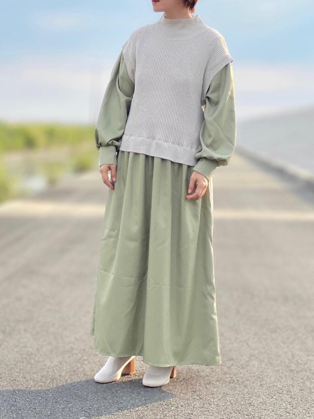 グリーン系のワンピース、ベージュ系のブーツを着用したレディースの秋コーディネートの2枚目の写真