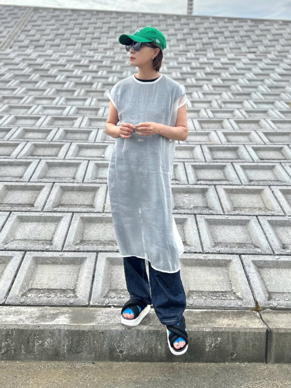 ブラック系のサンダル、ブルー系のサロペット/オーバーオール、ホワイト系のワンピースを着用したレディースの夏コーディネートの2枚目の写真