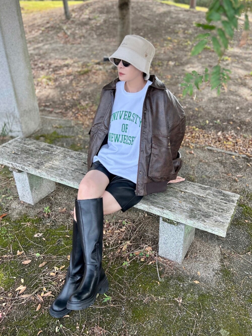 ブラウン系のブルゾン、ホワイト系のスウェット、ブラック系のパンツを着用したレディースの秋コーディネートの5枚目の写真