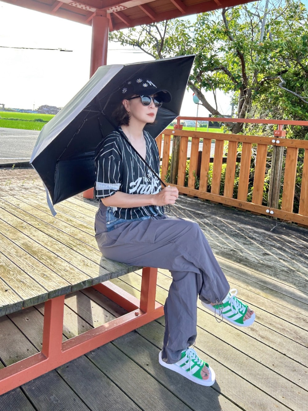 ホワイト系のキャミソール、ブラック系のシャツ/ブラウス、グレー系のカーゴパンツを着用したレディースの夏コーディネートの3枚目の写真