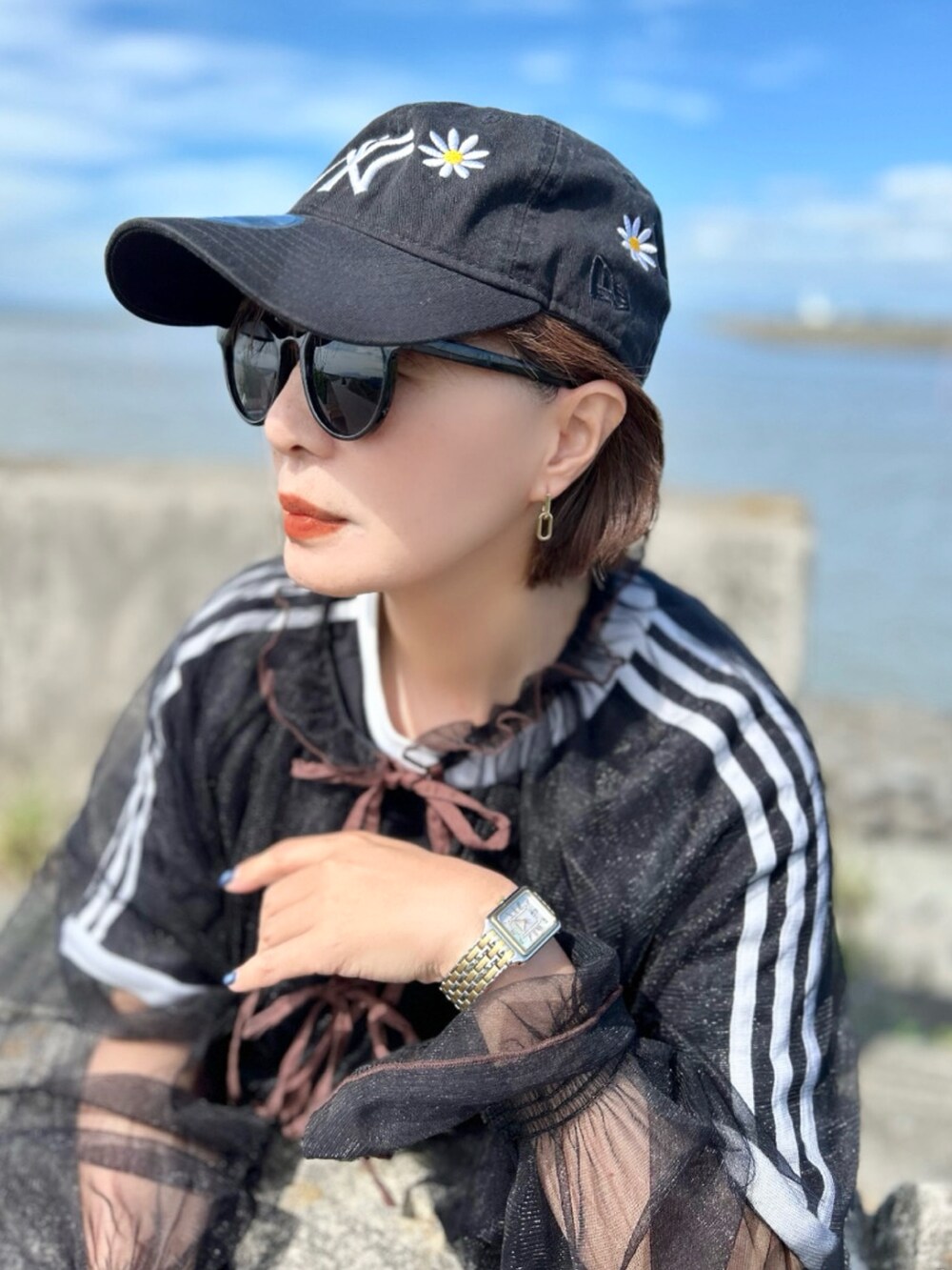 ブラック系のTシャツ/カットソー、ブラック系のワンピース、ブルー系のデニムパンツを着用したレディースの秋コーディネートの2枚目の写真