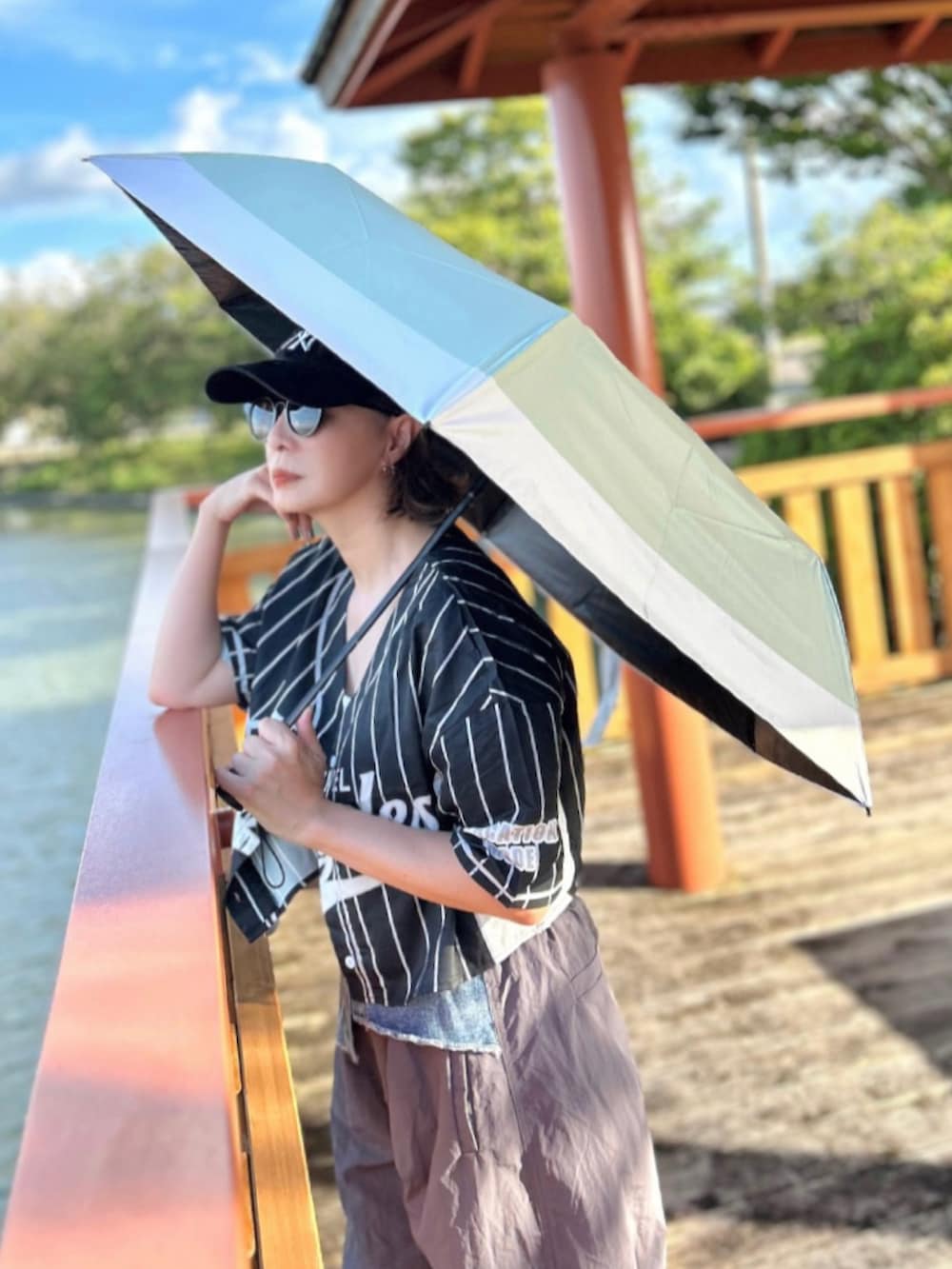 ホワイト系のキャミソール、ブラック系のシャツ/ブラウス、グレー系のカーゴパンツを着用したレディースの夏コーディネートの2枚目の写真