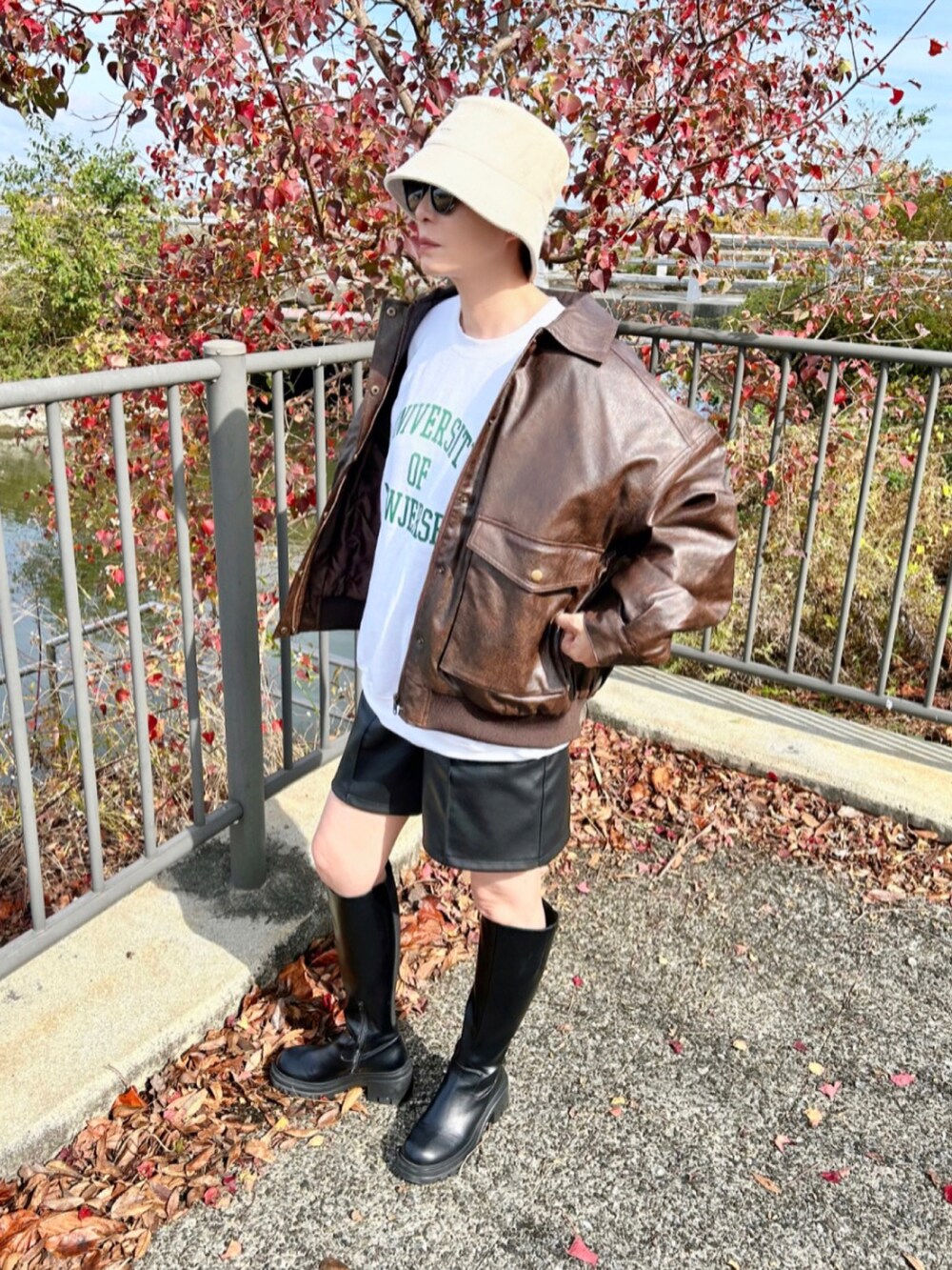 ブラウン系のブルゾン、ホワイト系のスウェット、ブラック系のパンツを着用したレディースの秋コーディネートの3枚目の写真