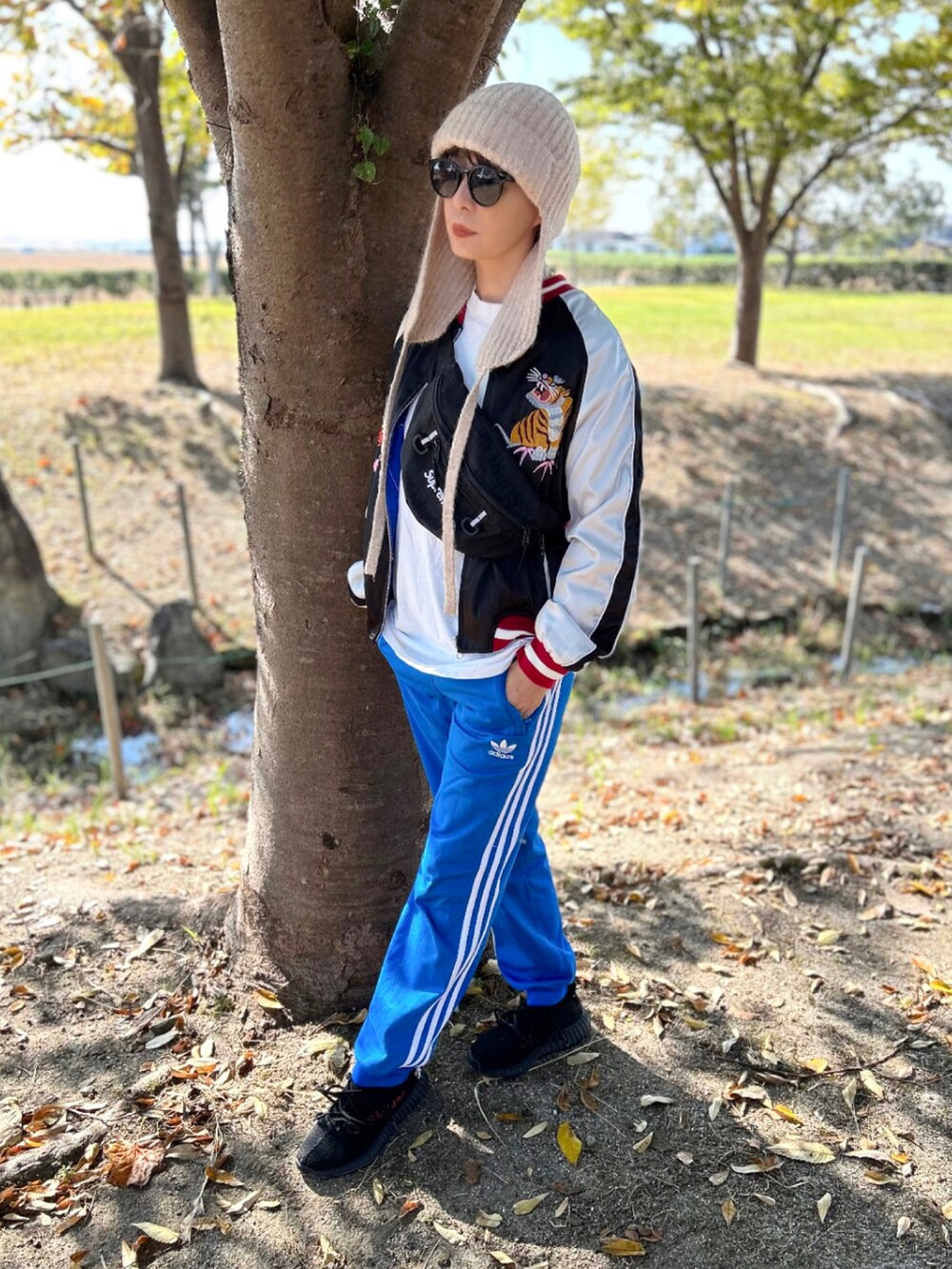 ブルー系のその他パンツ、ブラック系のスカジャン、ブラック系のスニーカーを着用したレディースの秋コーディネートの4枚目の写真