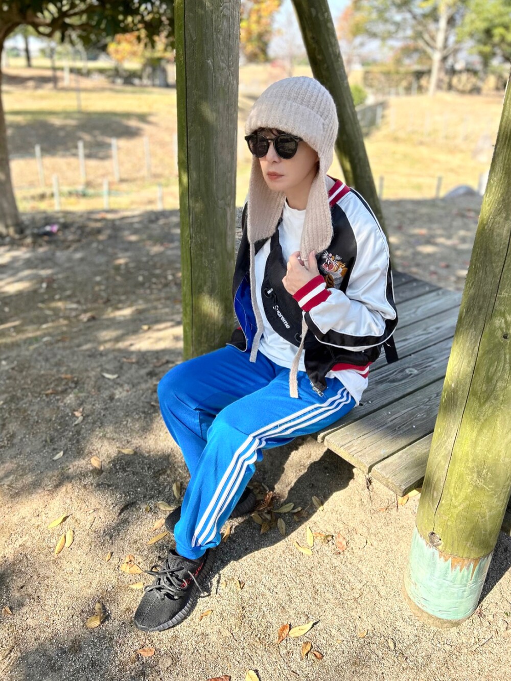 ブルー系のその他パンツ、ブラック系のスカジャン、ブラック系のスニーカーを着用したレディースの秋コーディネートの2枚目の写真