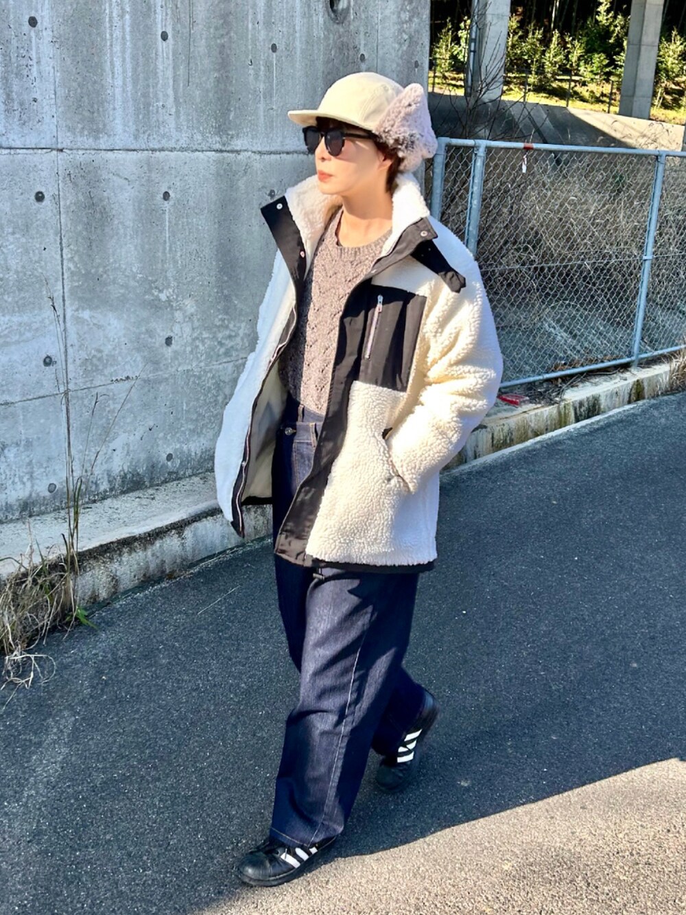 ホワイト系のブルゾン、ブラウン系のニット/セーター、ブルー系のその他パンツを着用したレディースの冬コーディネートの2枚目の写真