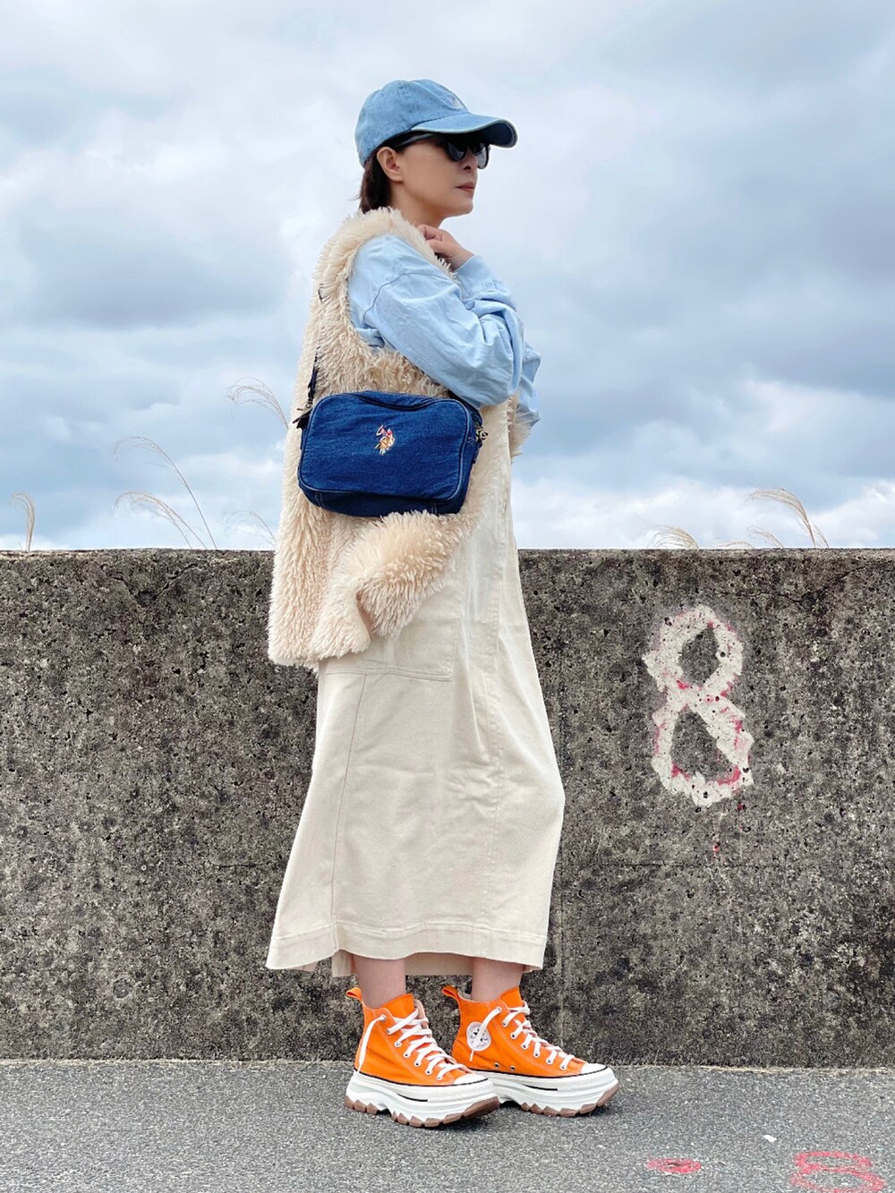 ブルー系のショルダーバッグ、ホワイト系のワンピース、ブルー系のTシャツ/カットソーを着用したレディースの春コーディネートの3枚目の写真