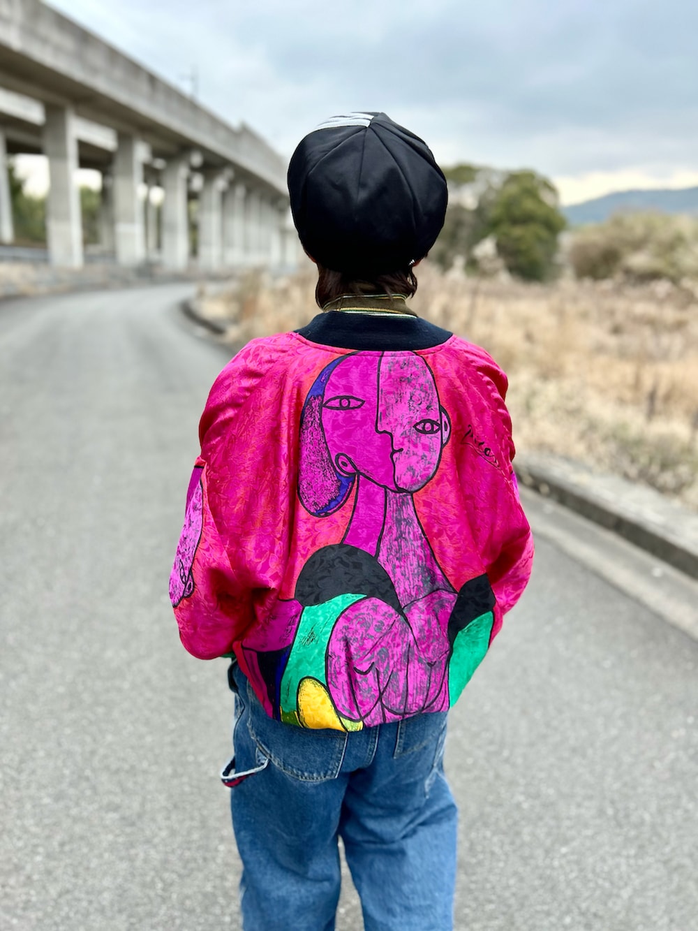 ブルー系のサロペット/オーバーオール、レッド系のブルゾン、グリーン系のトップスを着用したレディースの冬コーディネートの3枚目の写真