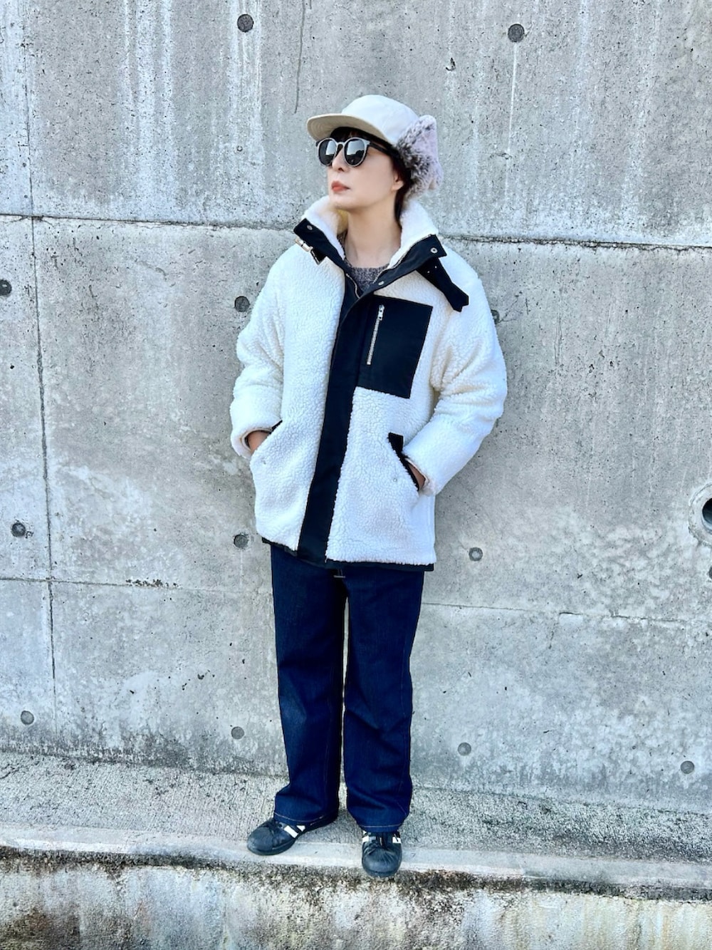 ホワイト系のブルゾン、ブラウン系のニット/セーター、ブルー系のその他パンツを着用したレディースの冬コーディネートの3枚目の写真