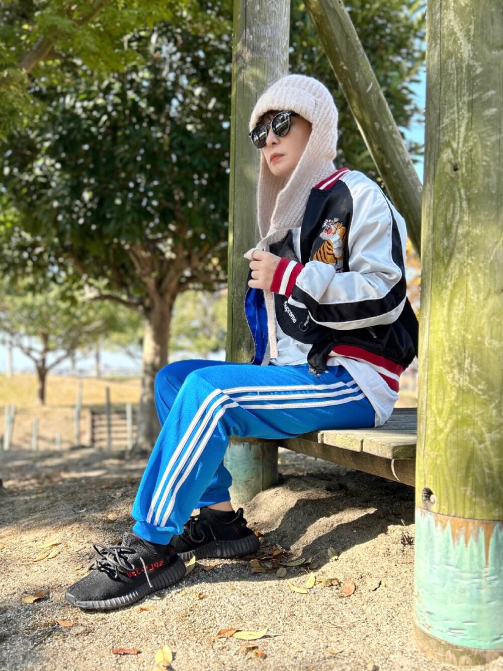 ブルー系のその他パンツ、ブラック系のスカジャン、ブラック系のスニーカーを着用したレディースの秋コーディネートの3枚目の写真