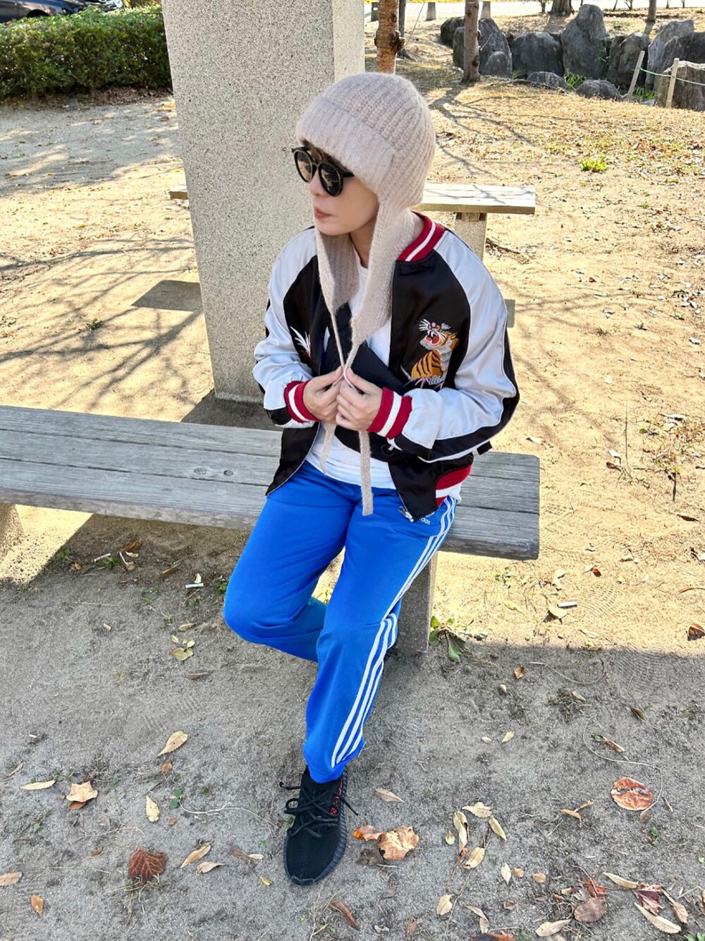 ブルー系のその他パンツ、ブラック系のスカジャン、ブラック系のスニーカーを着用したレディースの秋コーディネートの5枚目の写真