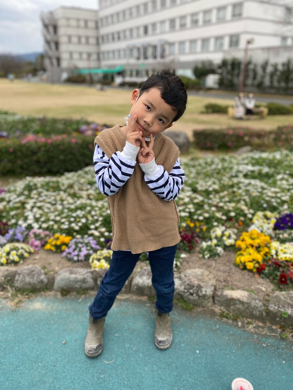 ブラウン系のベスト、ホワイト系のTシャツ/カットソー、ブルー系のデニムパンツを着用したキッズの春コーディネートの3枚目の写真