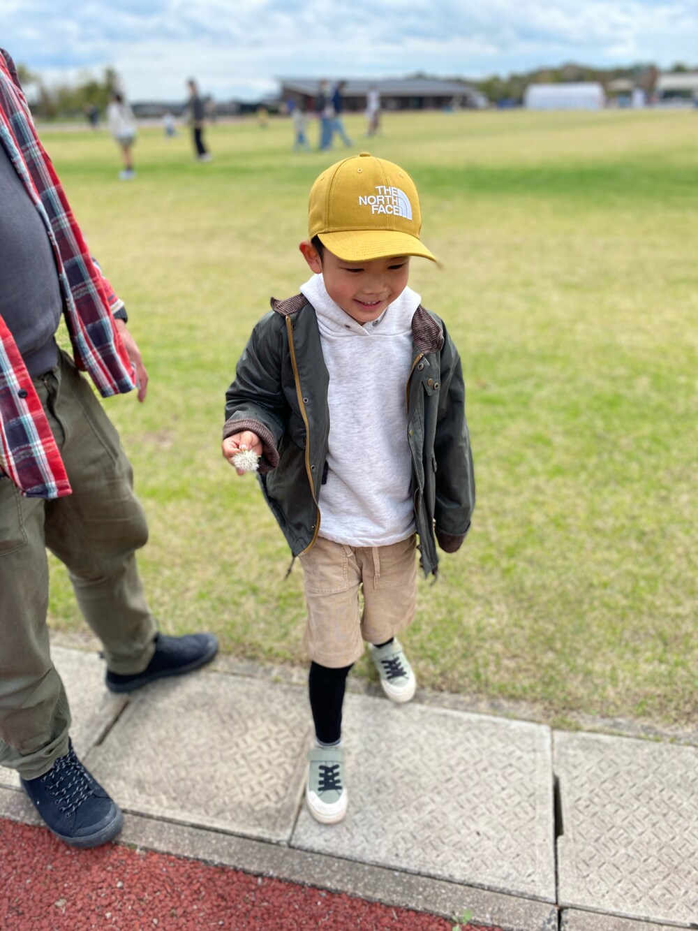 グリーン系のその他アウター、ベージュ系のその他パンツ、グリーン系のスニーカーを着用したキッズの春コーディネートの2枚目の写真