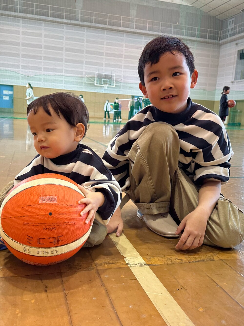 ブラック系のスウェット、ブラック系のスウェット、ベージュ系のチノパンツを着用したキッズの冬コーディネートの2枚目の写真