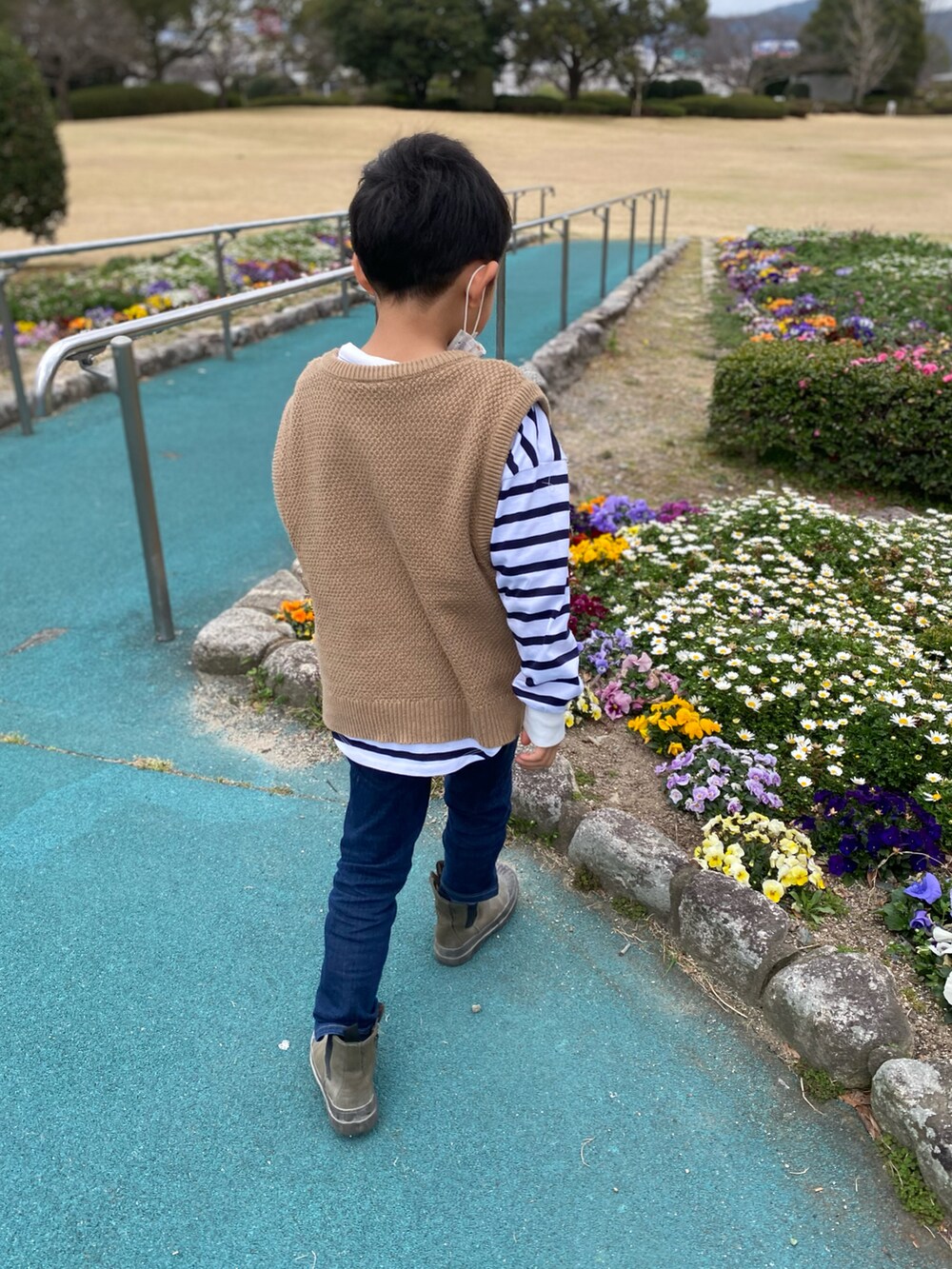 ブラウン系のベスト、ホワイト系のTシャツ/カットソー、ブルー系のデニムパンツを着用したキッズの春コーディネートの2枚目の写真