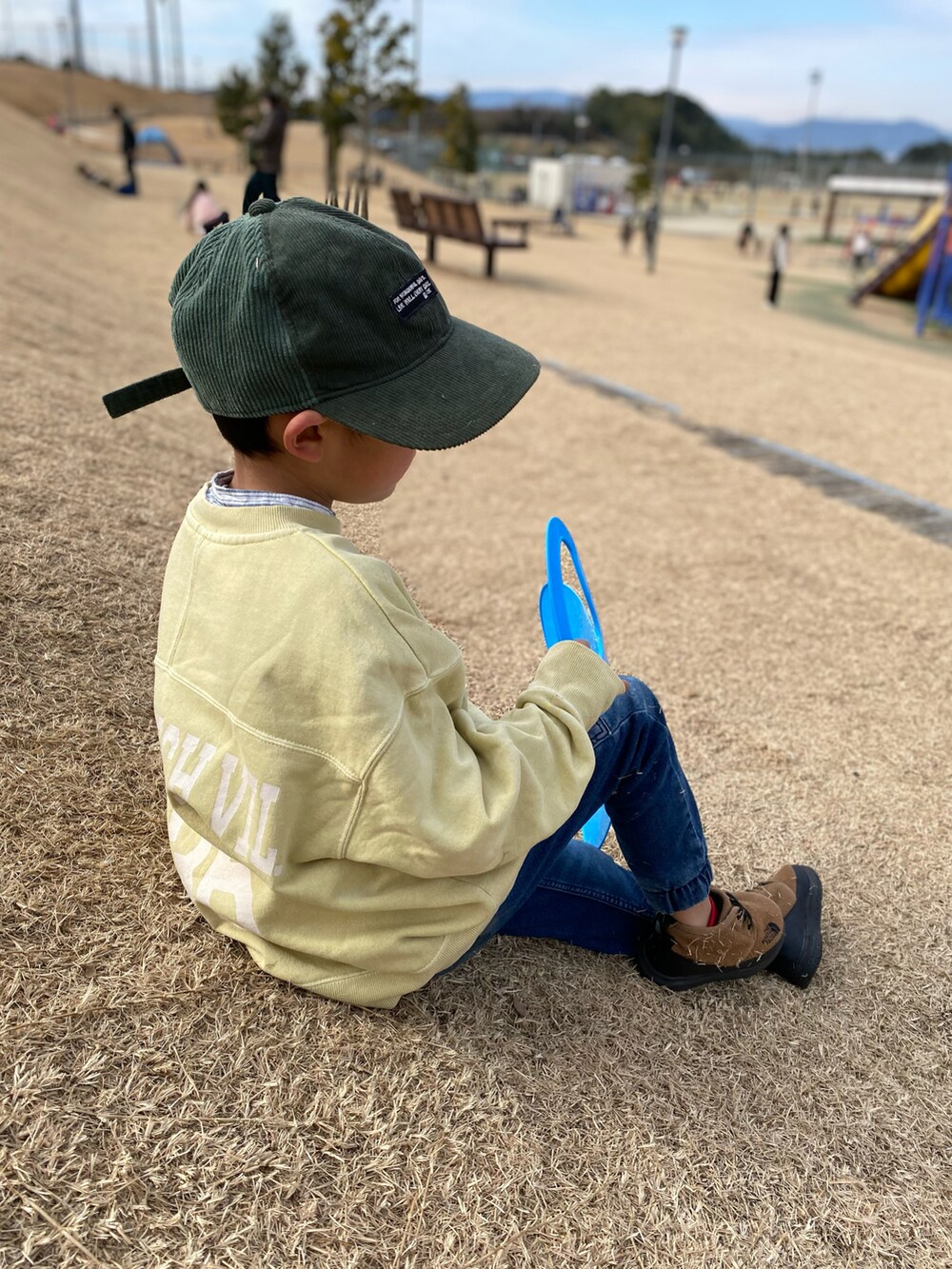 イエロー系のその他アウター、ブルー系のデニムパンツ、イエロー系のスウェットを着用したキッズの冬コーディネートの2枚目の写真