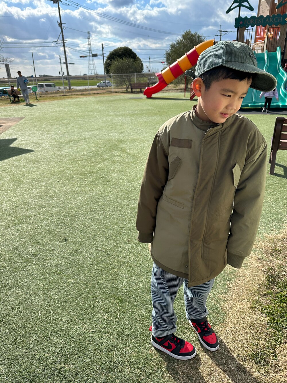 グリーン系のダウンジャケット/コート、その他のデニムパンツ、レッド系のスニーカーを着用したキッズの冬コーディネートの3枚目の写真