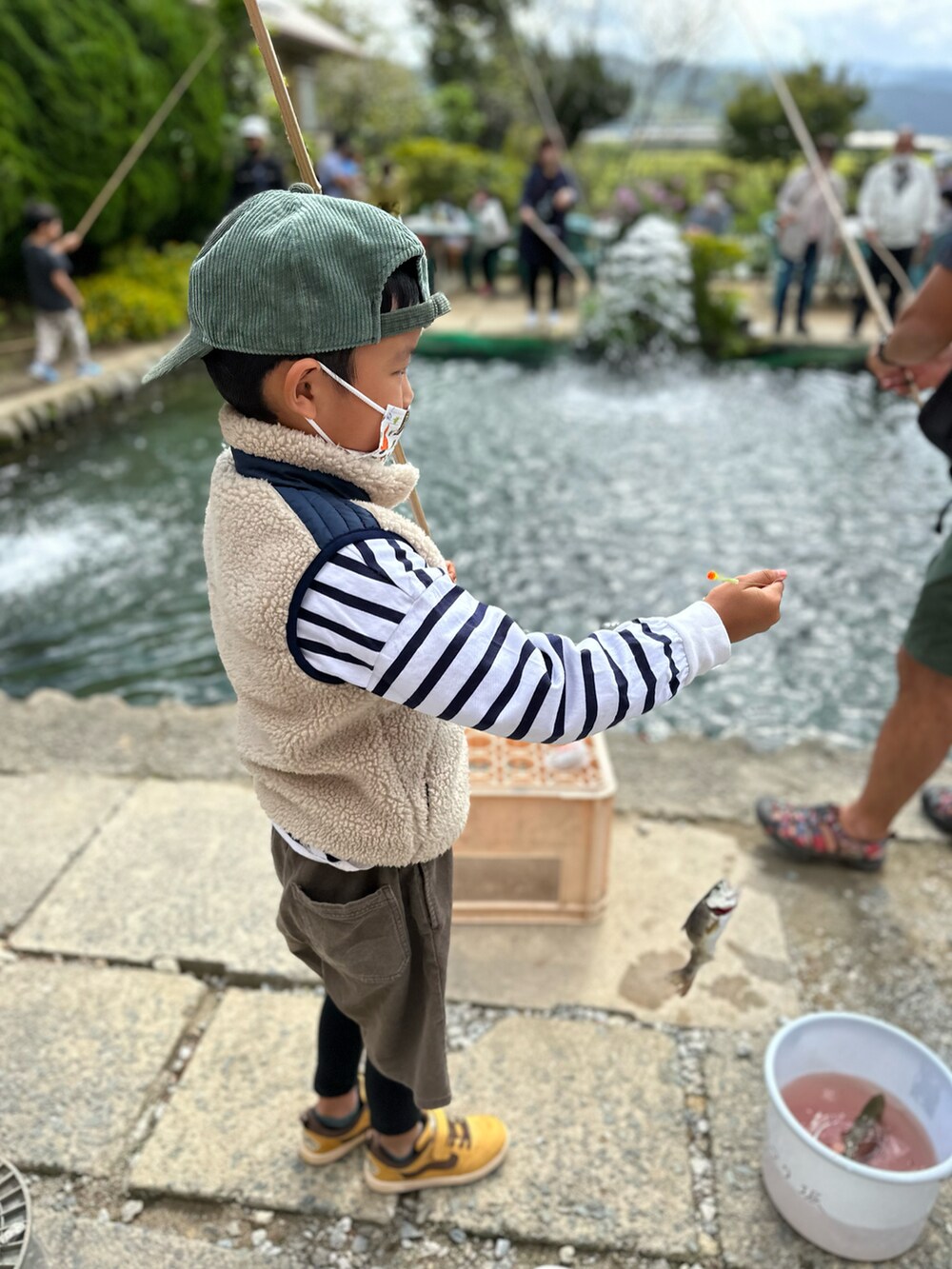 ベージュ系のベスト、ブラウン系のその他パンツ、イエロー系のスニーカーを着用したキッズの秋コーディネートの2枚目の写真