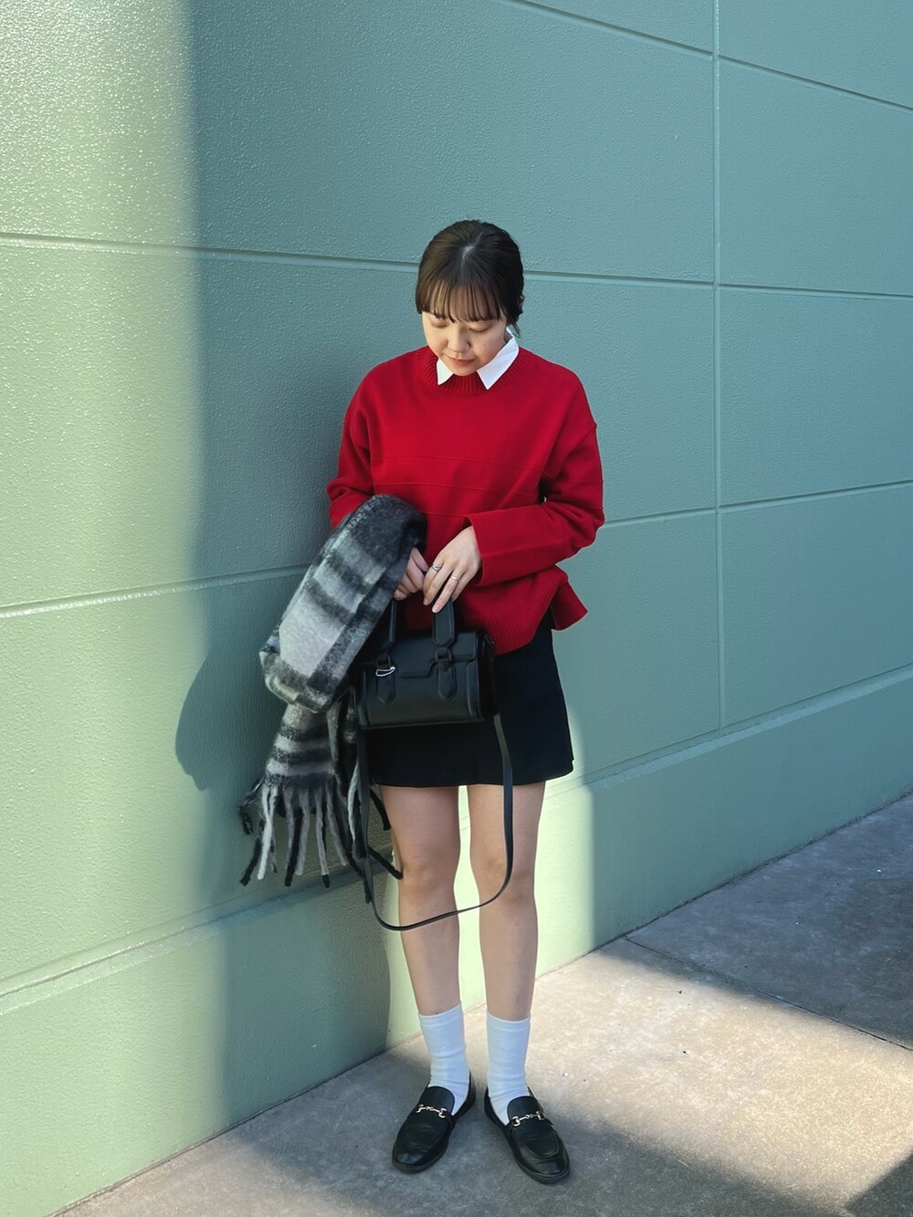 レッド系のニット/セーター、ブラック系のその他パンツ、ブラック系のストール/ショールを着用したレディースの冬コーディネートの3枚目の写真