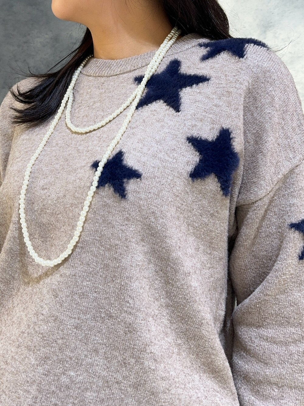 ベージュ系のニット/セーター、ホワイト系のスカートを着用したレディースの秋コーディネートの4枚目の写真