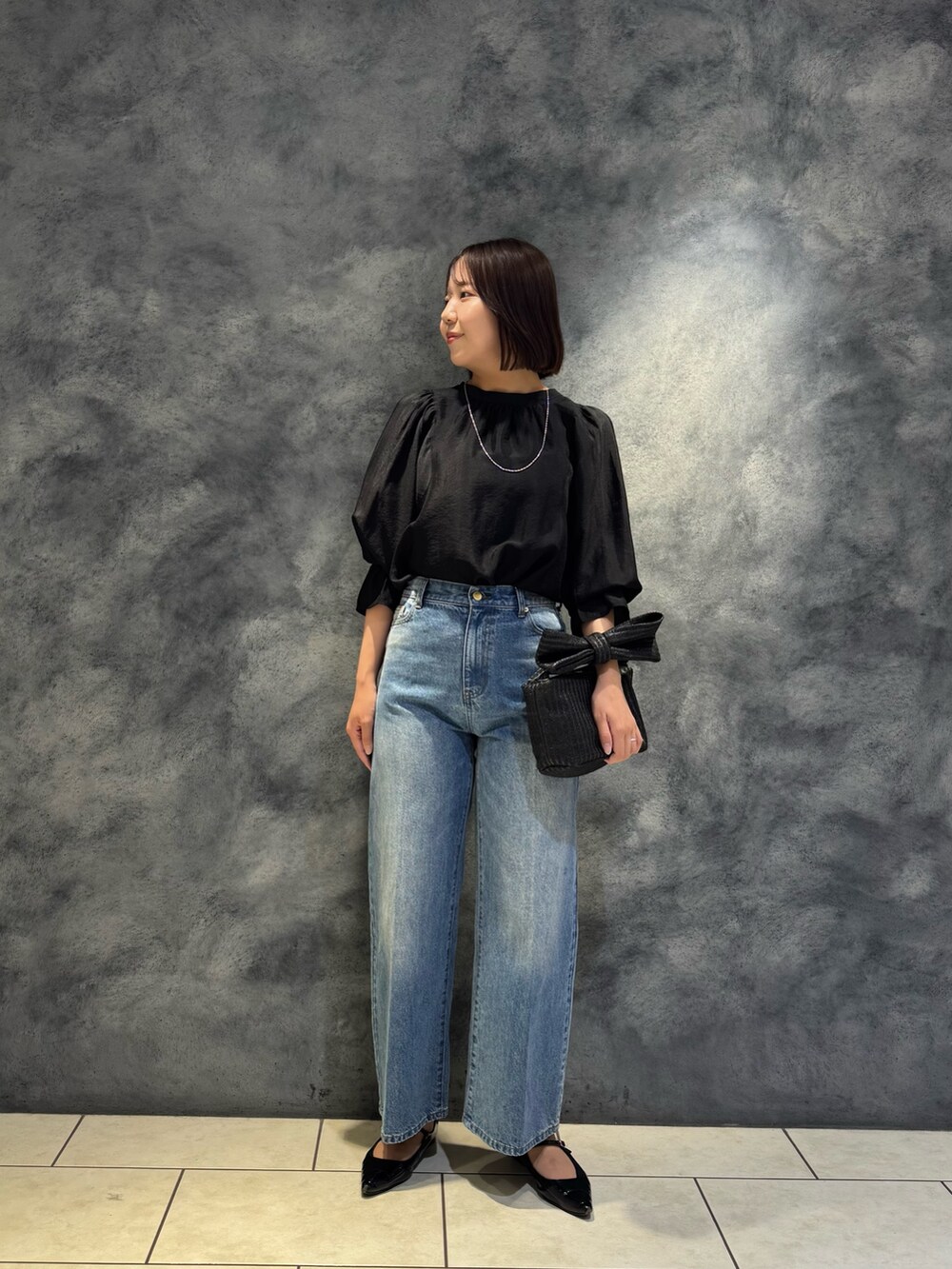 ブラック系のシャツ/ブラウス、ブルー系のデニムパンツを着用したレディースの春コーディネートの2枚目の写真