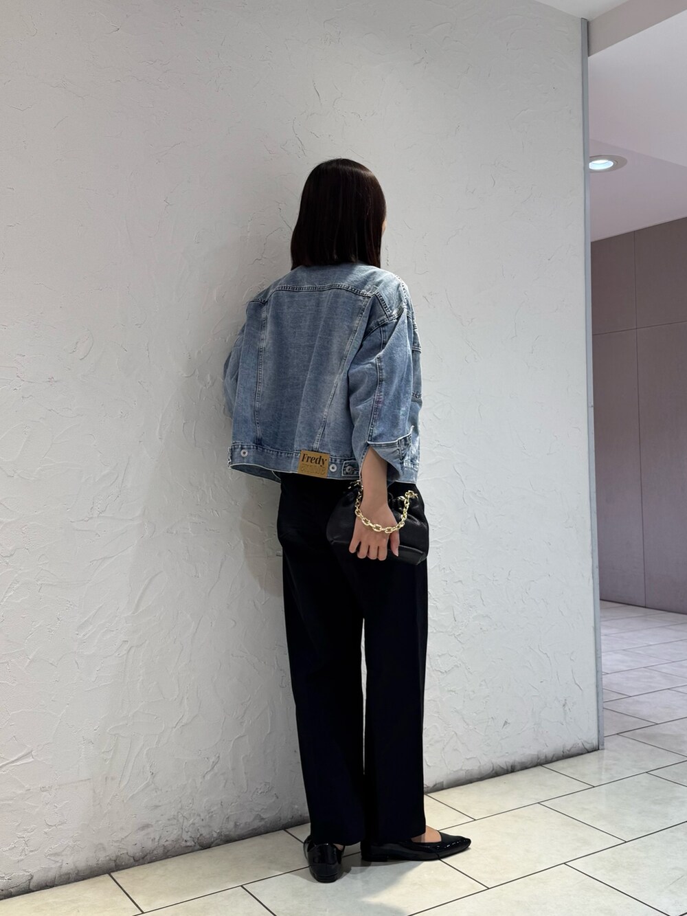 ブルー系のデニムジャケット、ブラック系のチノパンツ、ホワイト系のTシャツ/カットソーを着用したレディースの冬コーディネートの3枚目の写真